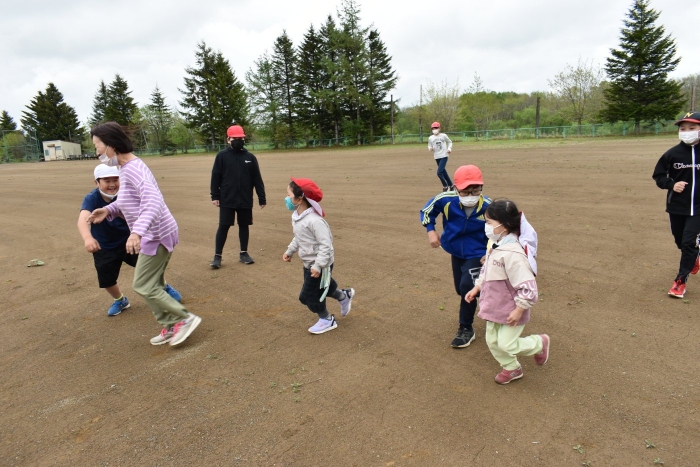 率先して鬼役に立候補する年中児，園児の走りに合わせ逃げる小学生