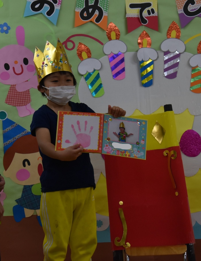 「手形，見せて―」の声に応え，友達の方へ絵本をくるり